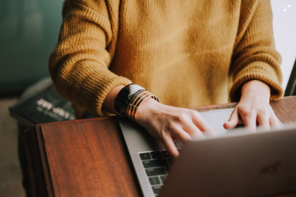 a person using a laptop on a wooden table ads interactive ad monetization platform