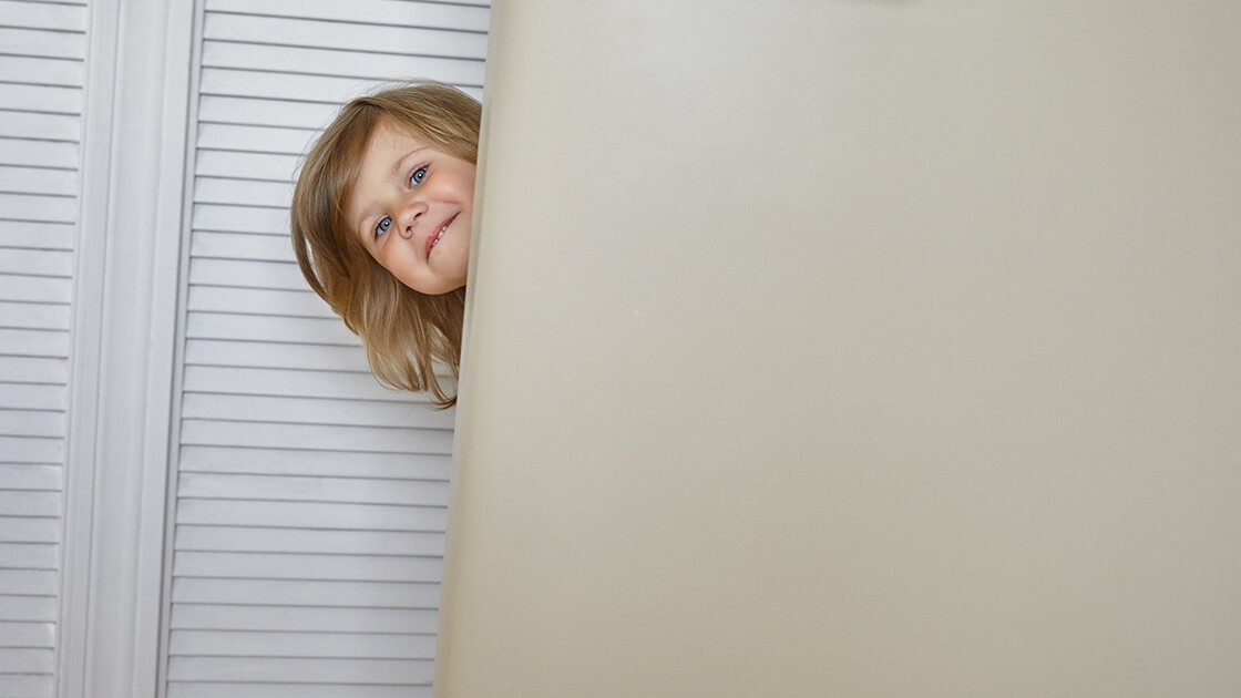 Little girl hiding behind door, illustrating viewability, ads interactive ad monetization platfrom